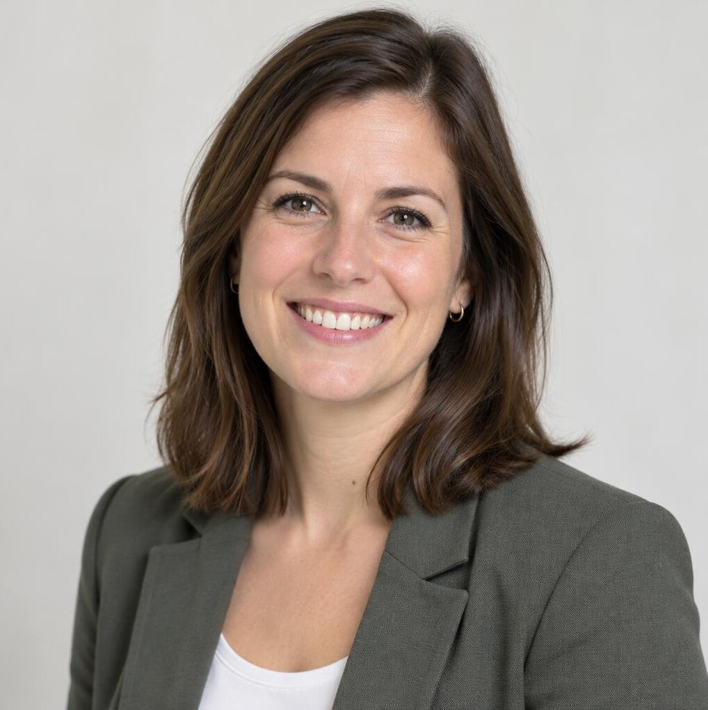 Portrait of a smiling woman with brown hair in a bright studio